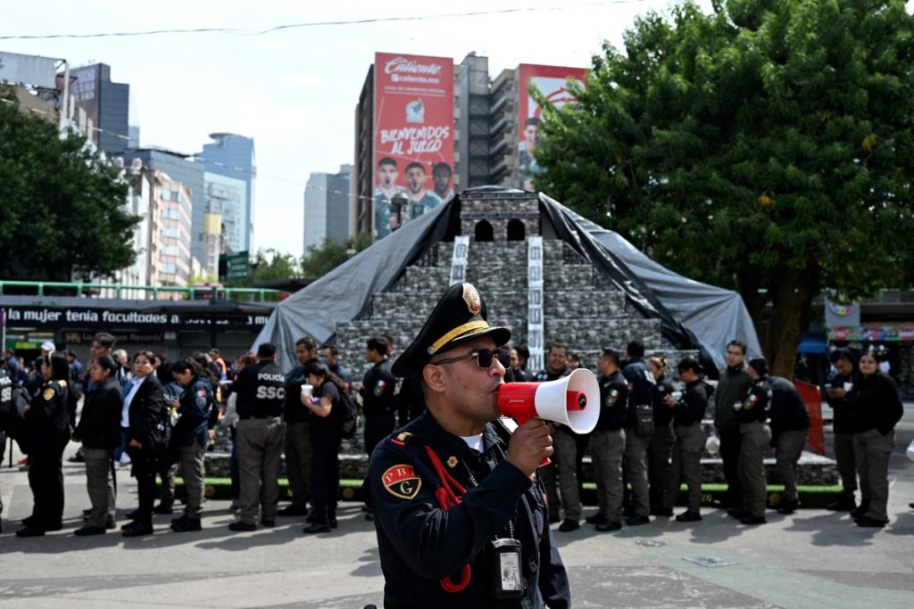Un miembro de la Secretaría de Seguridad de México guía a las personas tras el terremoto registrado este 17 de julio. Foto: AFP