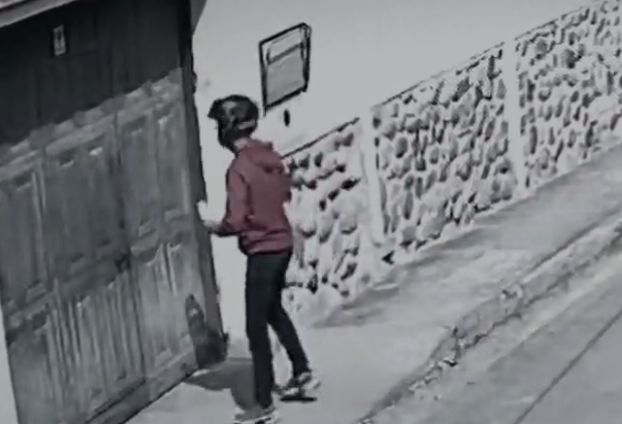 En un vídeo quedó registrado cómo un hombre deja un panfleto en una vivienda en Cuenca. Foto captura