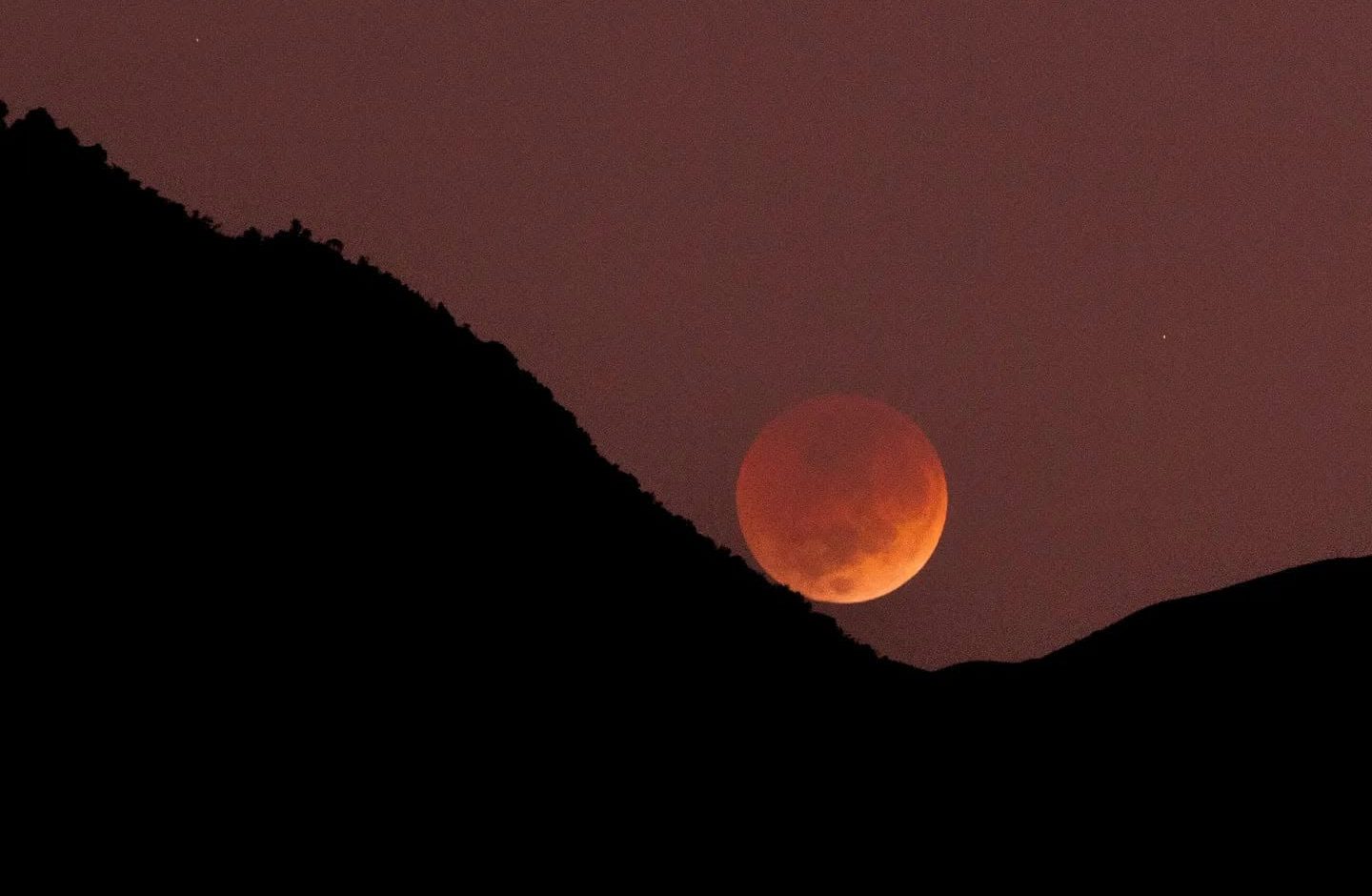 Una luna naranja por un eclipse lunar visto desde Cuenca, el 8 de noviembre de 2022. Foto: Andrés Mazza para El Mercurio
