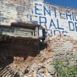 La caída de un muro en el Cementerio General de la parroquia Baños, dejó expuesto un féretro. /Cortesía
