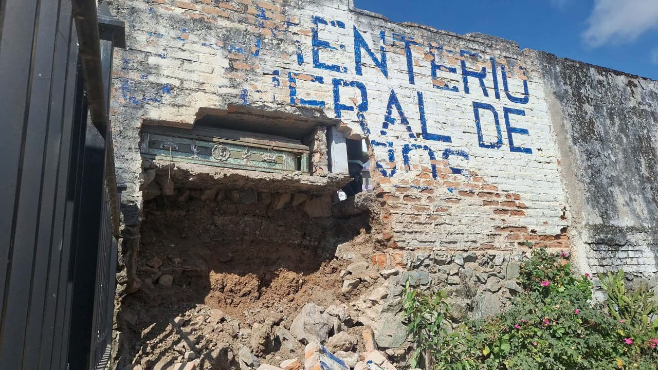 La caída de un muro en el Cementerio General de la parroquia Baños, dejó expuesto un féretro. /Cortesía