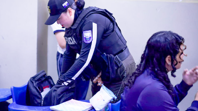 La Policía Nacional llevó a cabo un operativo preventivo en la Unidad Educativa Vicente Rocafuerte, ubicada en la ciudad de Guayaquil, este 5 de octubre. En la intervención participaron los ministros Guilda Alcívar y John Reimberg. Los agentes policiales ingresaron a las aulas, acompañados de canes especializados, y asimismo inspeccionaron espacios del plantel para identificar posibles riesgos. El operativo se realizó a través del Plan Escudo, una estrategia para evitar la infiltración del crimen organizado en las escuelas y colegios de Ecuador. De acuerdo a información que compartió el Ministerio de Educación, hasta la fecha se han hecho 16 operativos en Ecuador. En las intervenciones se han retirado armas, objetos cortopunzantes, alcohol y sustancias sujetas a fiscalización. ¿Cuándo puede ingresar la Policía Nacional a las escuelas en Ecuador? El ingreso y la actuación de los servidores policiales en los centros educativos de Ecuador se rigen por un principio estricto de excepcionalidad y por lo dispuesto en el Acuerdo Interministerial Nro. MINEDEC-MDI-2026-006-AI. En los lineamientos del Plan Escudo, los operativos de prevención no se realizan de forma arbitraria, sino que debe haber una solicitud formal de los representantes del establecimiento educativo frente a riesgos o amenazas detectadas previamente. Asimismo, la Policía solo puede ingresar a una institución educativa cuando exista una orden judicial expresa emitida por la autoridad competente, cuando exista un caso de delito flagrante, para impedir la consumación de una infracción penal, para socorrer a víctimas de un accidente, o en situaciones de peligro cierto contra la integridad de cualquier miembro de la comunidad educativa. (I)